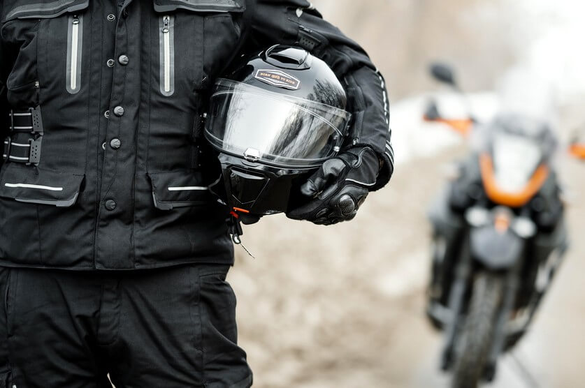 Motorradfahrer-Team mit seinem Motorradhelm auf der Hand